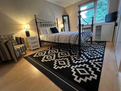 a bedroom with a bed and a black and white rug at Executive double bedroom with en-suite in Easthampstead
