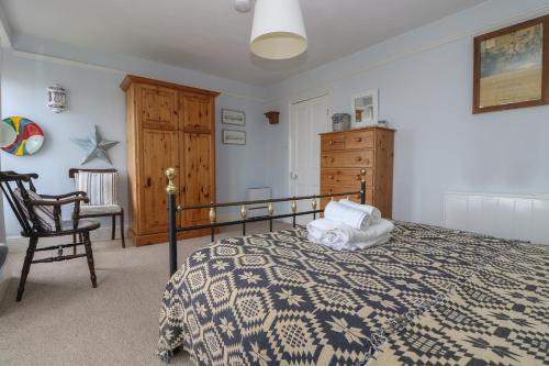 a bedroom with a bed and a chair at Lookout in Mousehole