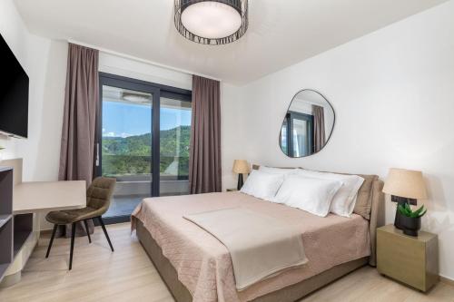 a bedroom with a bed and a desk and a window at Villa Butoniga Hills in Pazin