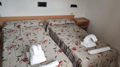 two beds in a hotel room with towels on them at Restaurante y Hostal San Paio in Santiago de Compostela