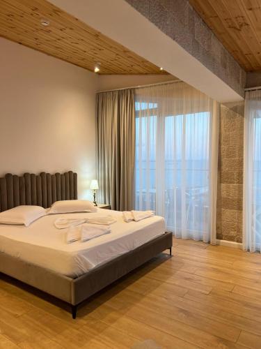 a bedroom with a large bed and a large window at Trevi Hotel & Restorant, Shengjin in Shëngjin