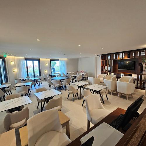 a restaurant with tables and chairs and a television at Ocean Beach Hotel in Skala Potamias
