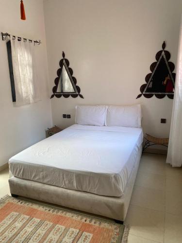 a bedroom with a white bed in a room at Riad Nour Resorts-Riad Nour Travel in Marrakech