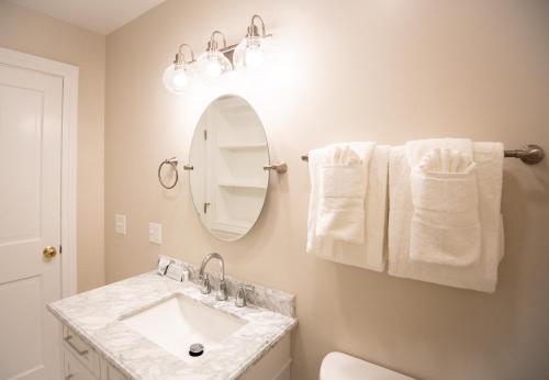 a bathroom with a sink and a mirror and towels at Cleftstone Inn in Bar Harbor
