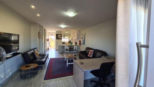 een woonkamer met een bank en een tafel bij Bright & Stylish in City Centre Swakopmund in Swakopmund