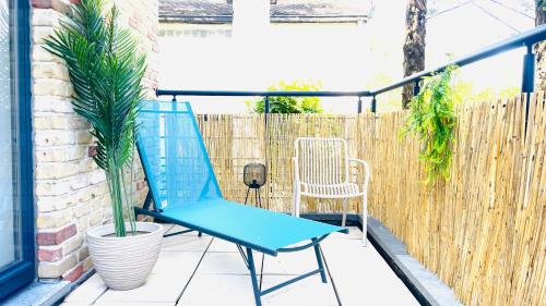 a blue chair on a patio with a fence at Friends & Family Brussels Atomium 6-8 pers in Grimbergen