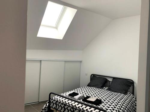 a bedroom with a black and white bed with a skylight at Gîte du Sabotier in Saint-Bonnet-près-Orcival