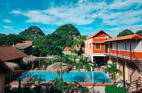 a resort with a swimming pool with mountains in the background at Trang An Village Homestay in Ninh Binh