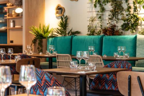 un restaurante con mesas de madera y sillas con copas de vino en L'Arcalod Hôtel Restaurant & Spa, en Doussard