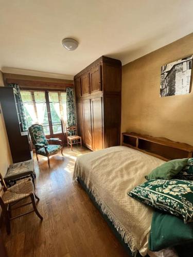 a bedroom with a bed and a chair at Maison atypique in Tende