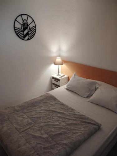 une chambre avec un lit et une horloge au mur dans l'établissement Mayflower, au Grau-du-Roi