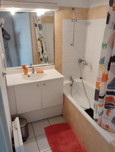 une salle de bain avec un lavabo, une baignoire et une douche dans l'établissement Mayflower, au Grau-du-Roi