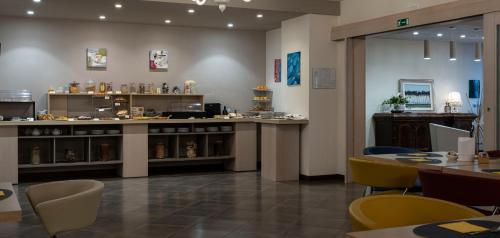a restaurant with a counter and tables and chairs at Il Castagneto Hotel in Melfi