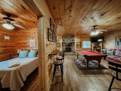 a log cabin bedroom with a bed and a pool table at Spacious, dog friendly cabin in Blowing Rock, NC in Blowing Rock