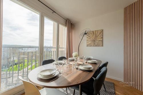 une salle à manger avec une table et une grande fenêtre dans l'établissement Confort & Spacieux Family Travel pour 6 - 10' to Disneyland Paris 25' to Paris - In front of Train Station Torcy RER A, à Torcy
