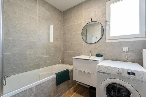une salle de bain avec un lave-linge et une baignoire dans l'établissement Confort & Spacieux Family Travel pour 6 - 10' to Disneyland Paris 25' to Paris - In front of Train Station Torcy RER A, à Torcy