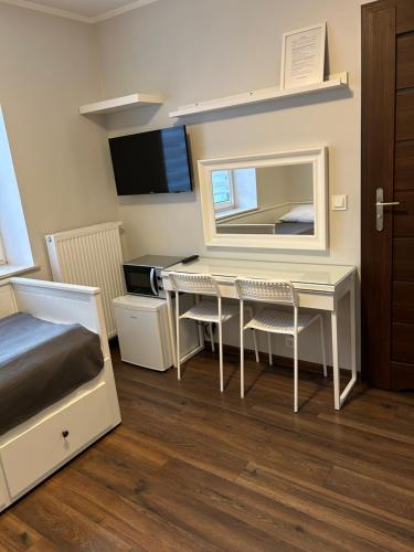 ヤスタルニャにあるJasのデスク、ベッド、鏡が備わる客室です。