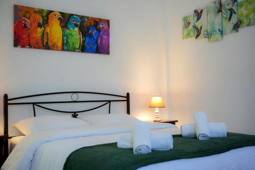 Frátsia的住宿－Green Parrot Apartments，一间卧室配有两张床,并画有鹦鹉