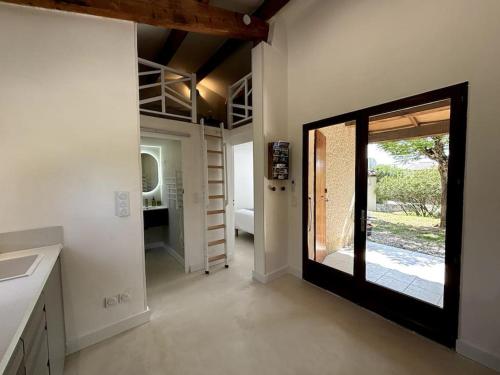 a hallway with a door leading to a room with a patio at L'Escale aux portes des Gorges de l'Ardèche in Saint-Martin-dʼArdèche