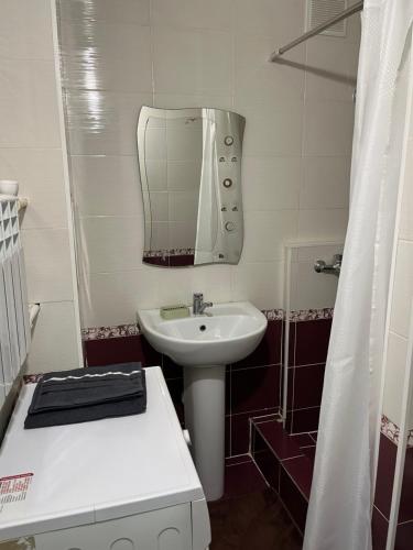 a small bathroom with a sink and a mirror at Уютная квартира в 4 мкр Авангарда in Atyraū