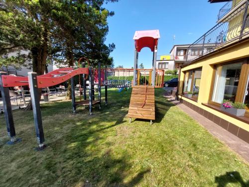 a playground in a yard with a swing set at Twoja Przystań Rodzinna in Jastrzębia Góra