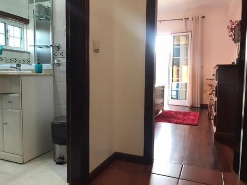 een keuken met een deur naar een badkamer met een wastafel bij Casa do Olival in Peso da Régua