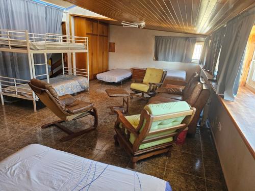 - un salon avec des chaises et des lits superposés dans l'établissement rosa de los vientos, à La Manga del Mar Meno