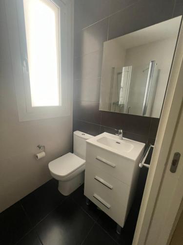 a bathroom with a white toilet and a sink at Egia donostia in San Sebastián