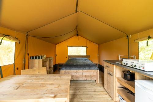 an interior view of a tent with a wooden floor at Safari tent 1 op Wellness Camping en B&B Stoltenborg in Winterswijk-Meddo
