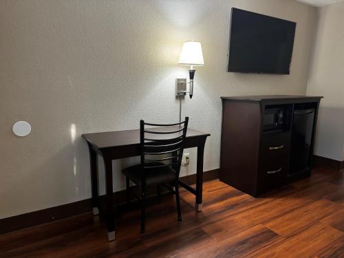 a room with a desk with a chair and a television at Super 8 by Wyndham Houston Webster NASA in Webster