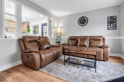 a living room with a brown leather couch and a table at 2 BDR -10 min de la Ronde et Parc Jean Drapeau South Shore Montreal in Longueuil