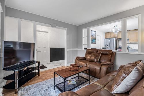 a living room with a couch and a table at 2 BDR -10 min de la Ronde et Parc Jean Drapeau South Shore Montreal in Longueuil