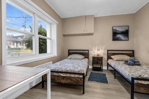 two beds in a room with a window at 2 BDR -10 min de la Ronde et Parc Jean Drapeau South Shore Montreal in Longueuil