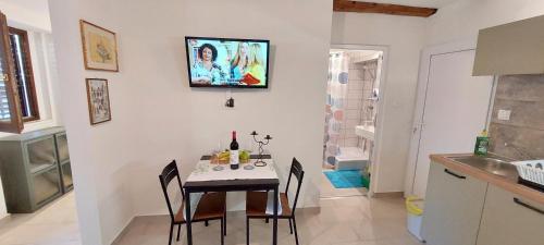 a dining room with a table and chairs in a kitchen at Apartman Villa Amelia in Mošćenička Draga