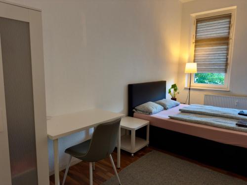 a small bedroom with a bed and a desk at Cozy room in Central Dortmund in Dortmund