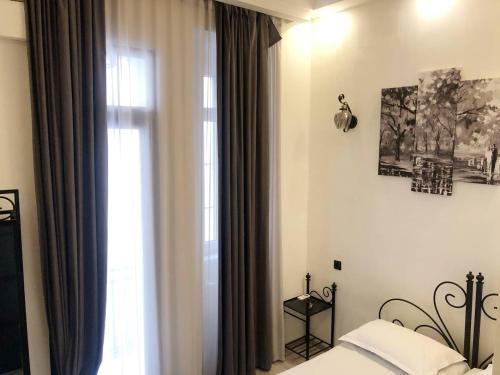 Schlafzimmer mit einem Bett und einem Fenster in der Unterkunft City Center Hotel in Tbilisi City