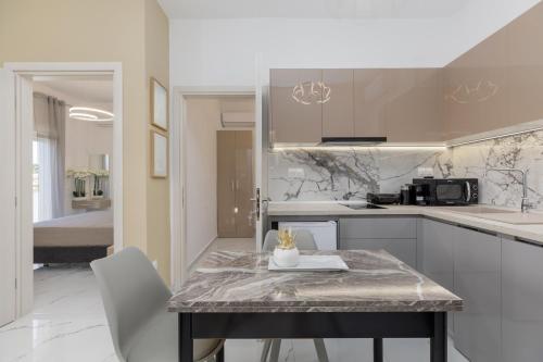 a kitchen with a table with chairs and a counter top at Stork Apartments in Hanioti