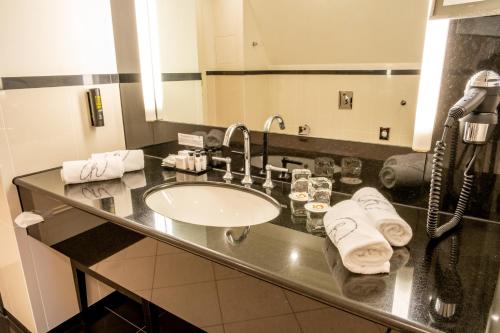 - un comptoir de salle de bains avec un lavabo et un téléphone dans l'établissement A La Cour d'Alsace by HappyCulture, à Obernai