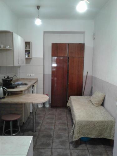 a kitchen with a bed and a table and a refrigerator at М.Арнаутская 33 in Odesa