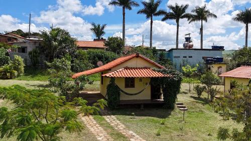 a small yellow house with a red roof at Chalés Vila Carrancas - Unidade Centro in Carrancas