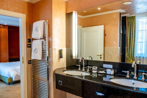 La salle de bains est pourvue de 2 lavabos et d'un grand miroir. dans l'établissement A La Cour d'Alsace by HappyCulture, à Obernai