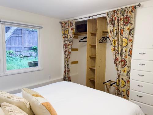 a bedroom with a bed and a window at Magnolia Garden Cottage in Seattle