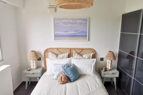 une chambre avec un lit avec des oreillers bleus et blancs dans l'établissement Spacieux 2 pièces avec terrasse, clim et parking, à Antibes