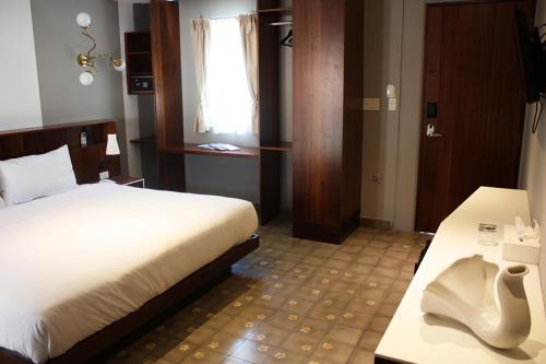 a bedroom with a bed and a desk and a window at Flor de Mayo Hotel & Restaurant in Cuernavaca