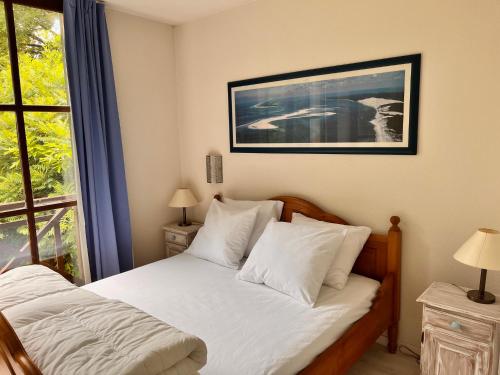 une chambre avec un lit avec des draps blancs et une fenêtre dans l'établissement Villa Bordeaux, à Salles