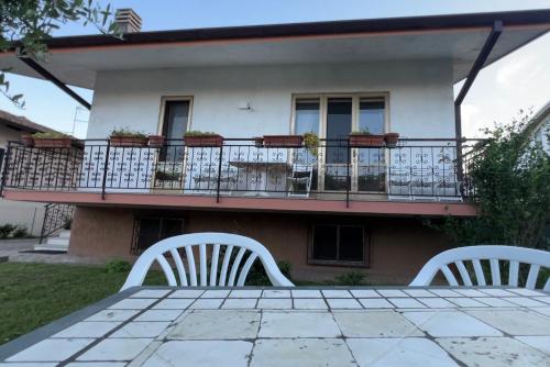 two white chairs sitting on a patio in front of a house at Villa Gianfranca - sentiti come a casa in Corno di Rosazzo