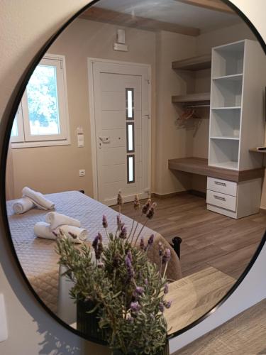 a mirror reflecting a bedroom with a bed and flowers at SeaEsta vasiliki 3 in Póndi