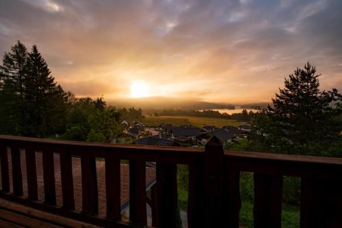 a view of a town at sunset from a deck at Panorama Kobylnice in Lipno nad Vltavou