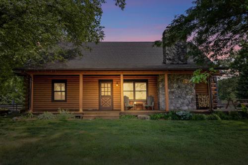 a log home with a porch and a patio at Scout's Haven in Rolling Prairie