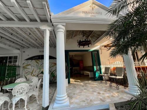 a white porch with white chairs and a table at Peregrinos Hostel Cartagena de Indias in Cartagena de Indias